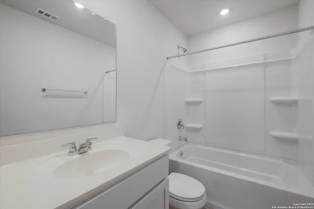 a bathroom with a bathtub shower sink vanity and toilet