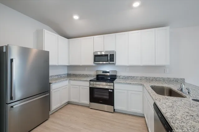 a kitchen with a sink stove and refrigerator