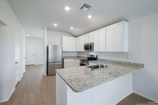 a kitchen with stainless steel appliances granite countertop a sink refrigerator and microwave