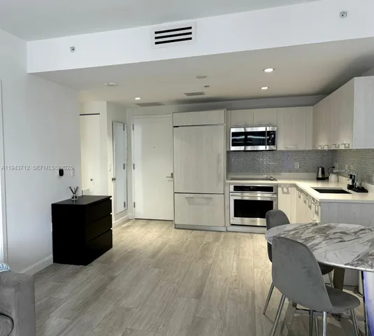 a kitchen with stainless steel appliances kitchen island granite countertop a stove a sink and a refrigerator