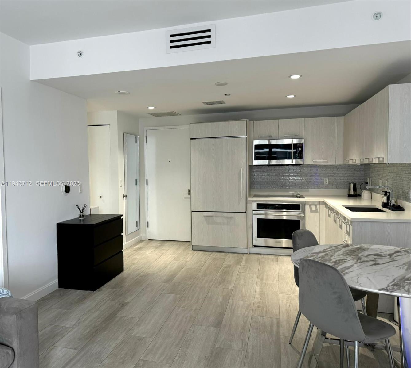 45 Southwest 9th Street, Unit 3107 Miami, FL 33130 - Photo 4 of 12 a kitchen with stainless steel appliances kitchen island granite countertop a stove a sink and a refrigerator