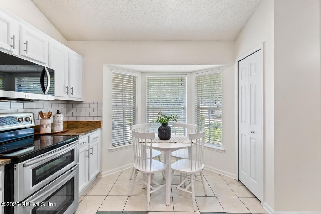 12223 Springmoor One Court Jacksonville, FL 32225 - Photo 11 of 29 a kitchen with a stove a sink and a microwave