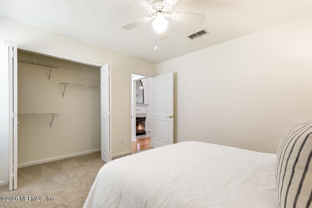 12223 Springmoor One Court Jacksonville, FL 32225 - Photo 13 of 29 a bedroom with a bed and a chandelier