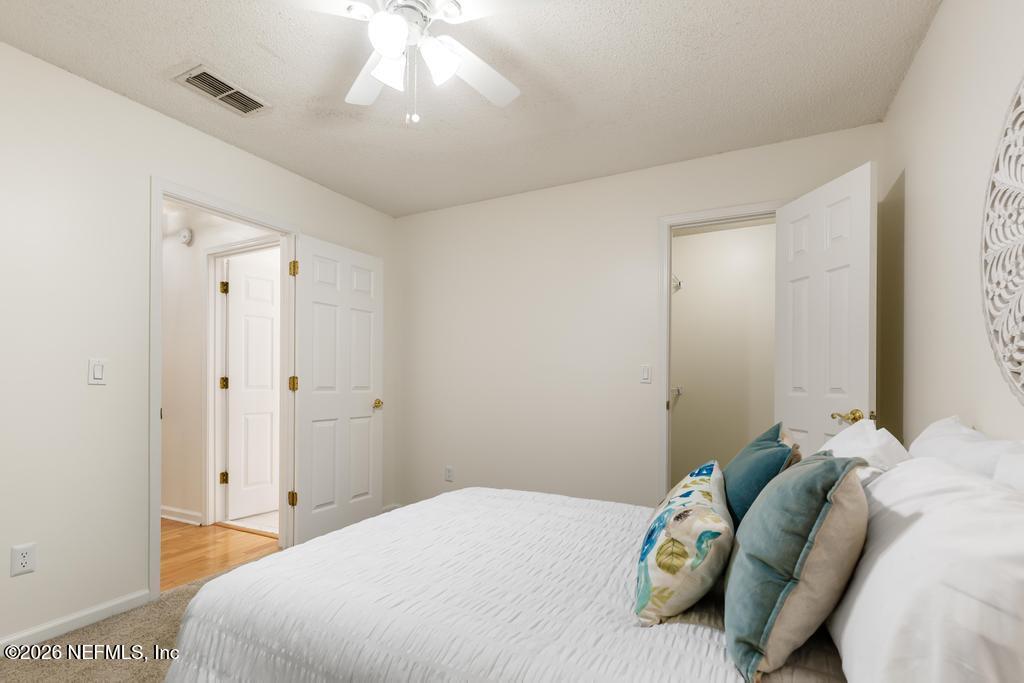 12223 Springmoor One Court Jacksonville, FL 32225 - Photo 16 of 29 a bedroom with a bed and a chandelier