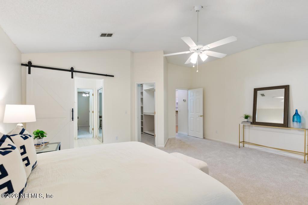 12223 Springmoor One Court Jacksonville, FL 32225 - Photo 18 of 29 a bedroom with a bed and a chandelier