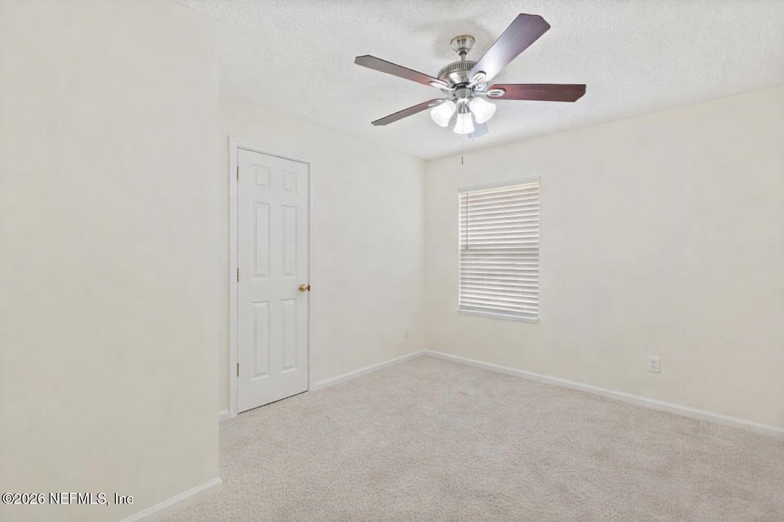 12223 Springmoor One Court Jacksonville, FL 32225 - Photo 20 of 29 an empty room with a chandelier fan and windows