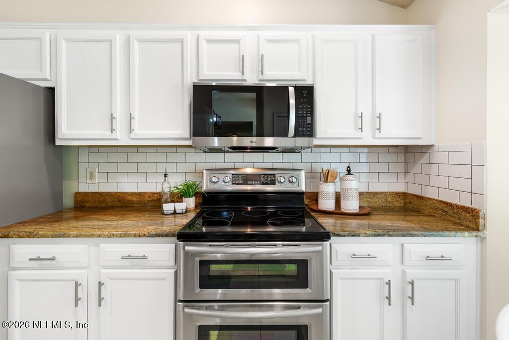 12223 Springmoor One Court Jacksonville, FL 32225 - Photo 9 of 29 a kitchen with granite countertop white cabinets and appliances
