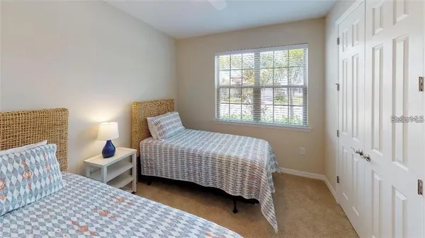 a bedroom with a bed lamp and a window