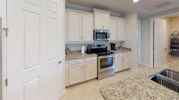 a kitchen with white cabinets and white appliances