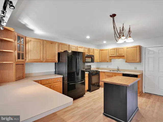 a kitchen with a refrigerator a stove top oven a sink and dishwasher