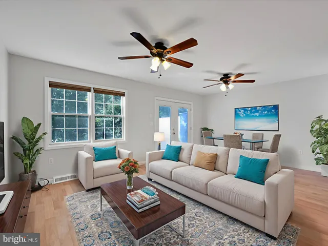 a living room with furniture ceiling fan and a window