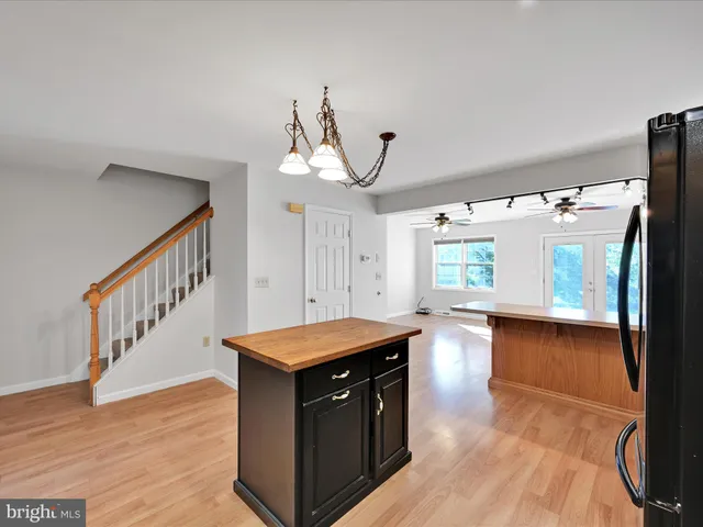 a kitchen that has a lot of cabinets in it and wooden floor