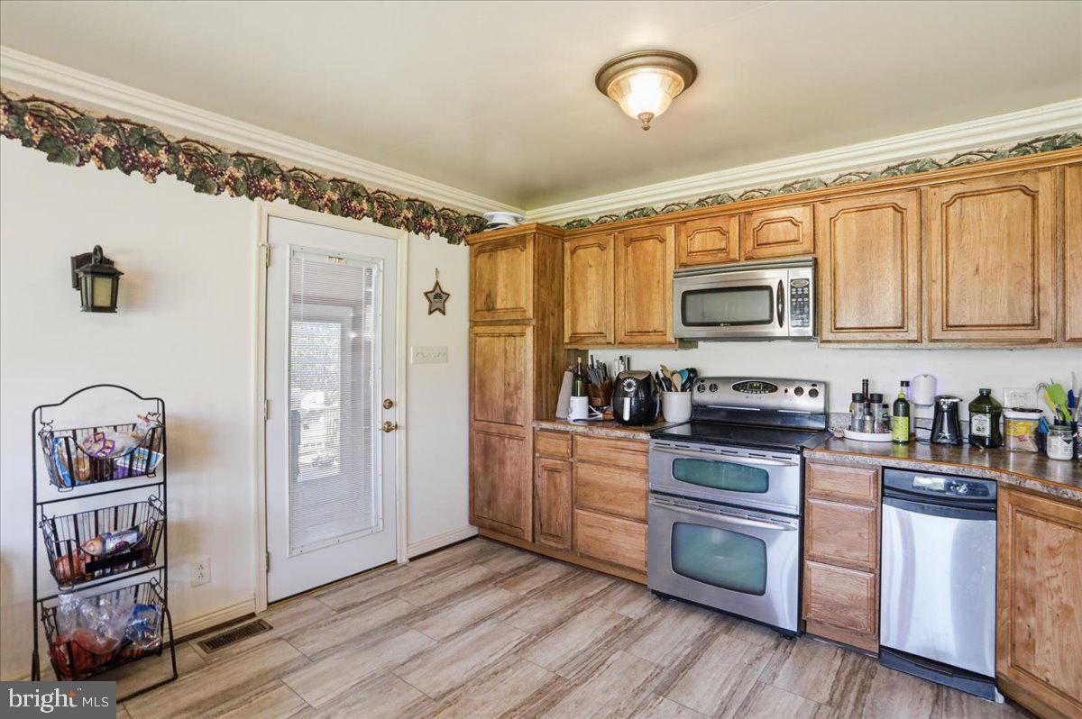 1264 Tearcoat Road Augusta, WV 26704 - Photo 10 of 43 a kitchen with stainless steel appliances granite countertop a stove a sink and a refrigerator