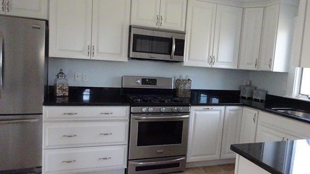 54 Jefferson Shores Road Buzzards Bay, MA 02532 - Photo 12 of 28 a kitchen with granite countertop white cabinets and stainless steel appliances