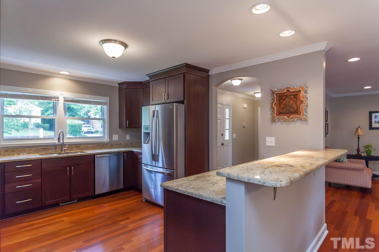 3145 Merrianne Drive Raleigh, NC 27607 - Photo 7 of 25 a kitchen with stainless steel appliances granite countertop a refrigerator and a sink
