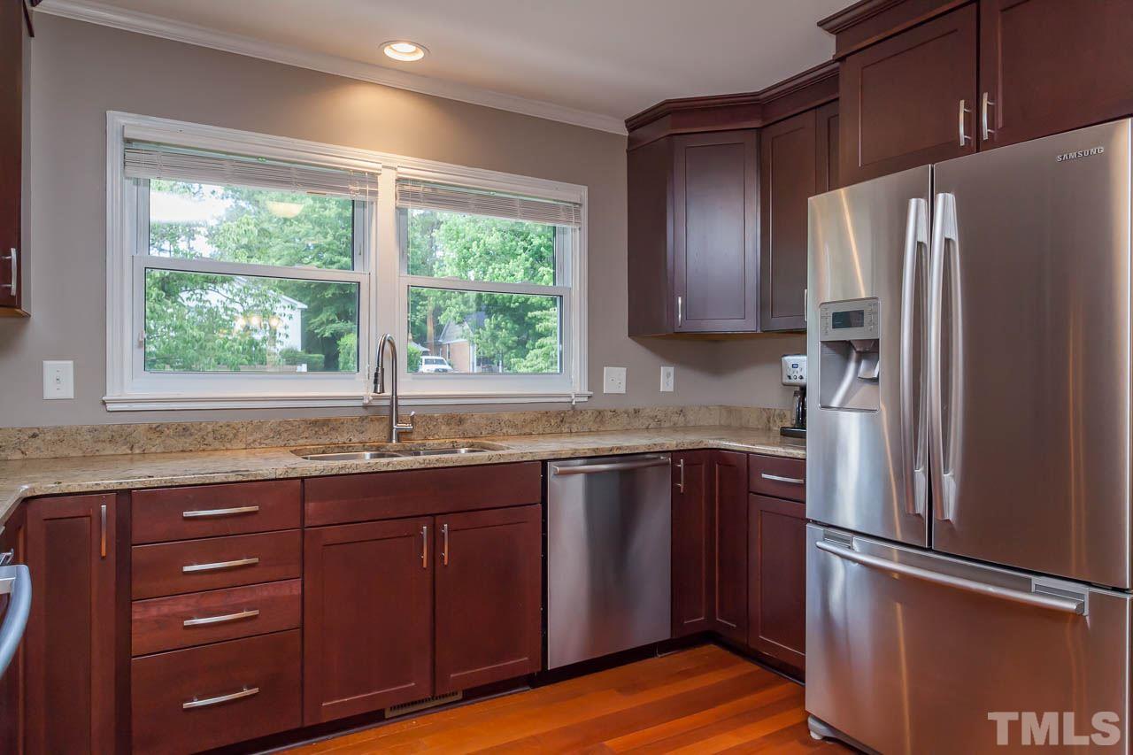 3145 Merrianne Drive Raleigh, NC 27607 - Photo 10 of 25 a kitchen with granite countertop stainless steel appliances a refrigerator cabinets and wooden floor