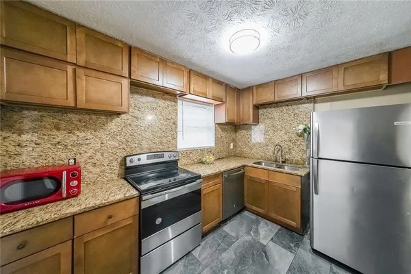 a kitchen with stainless steel appliances granite countertop a stove a refrigerator and a sink