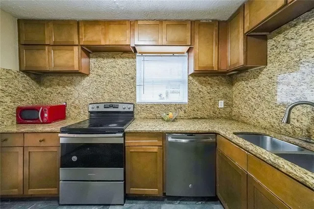 a kitchen with stainless steel appliances granite countertop a sink and a stove