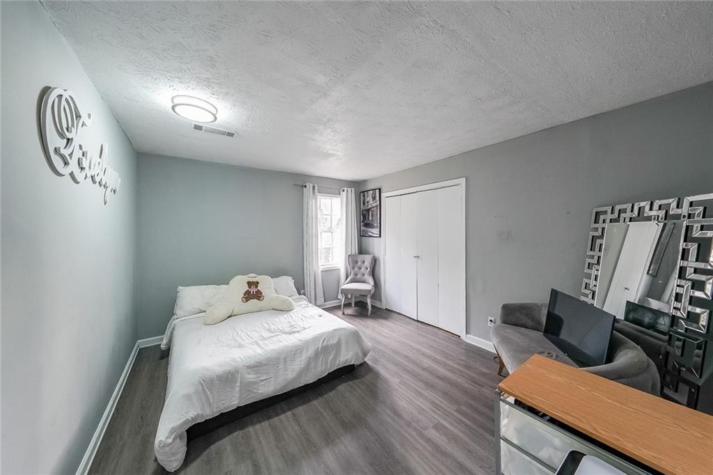 400 Winding River Drive, Unit E Atlanta, GA 30350 - Photo 21 of 34 a bedroom with a bed and wooden floor