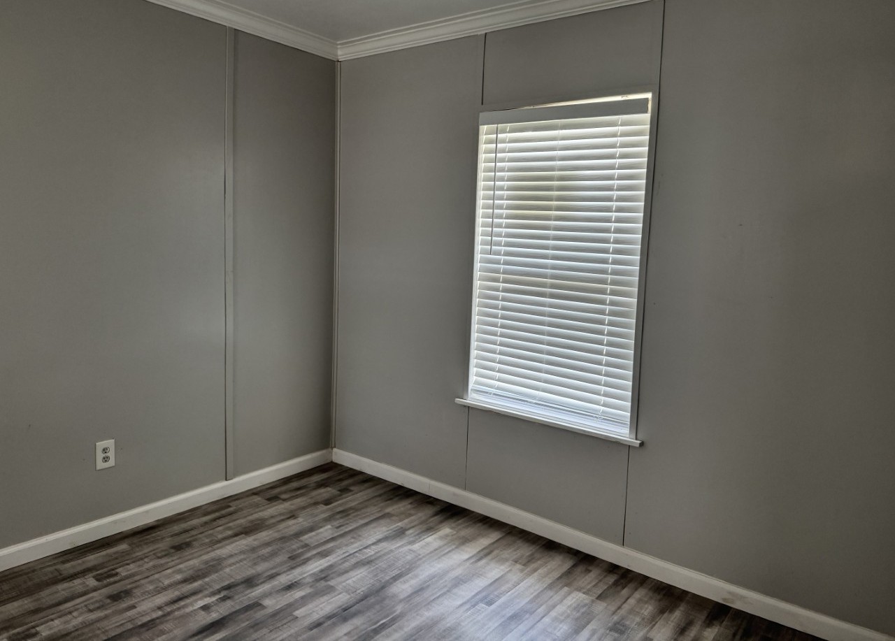 1813 Rhodes Road Austin, TX 78721 - Photo 5 of 14 Laminate wood flooring and crown molding elevate this versatile room, ready for your personalized touch.