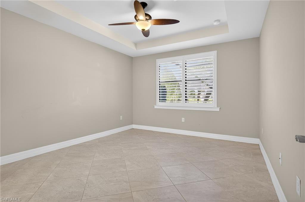 6345 Liberty Street Ave Maria, FL 34142 - Photo 17 of 35 an empty room with windows and chandelier fan