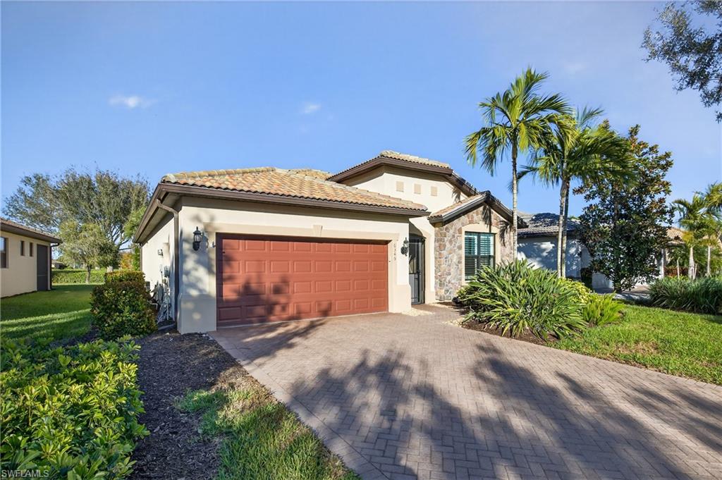6345 Liberty Street Ave Maria, FL 34142 - Photo 33 of 35 a front view of a house with a garden and a yard