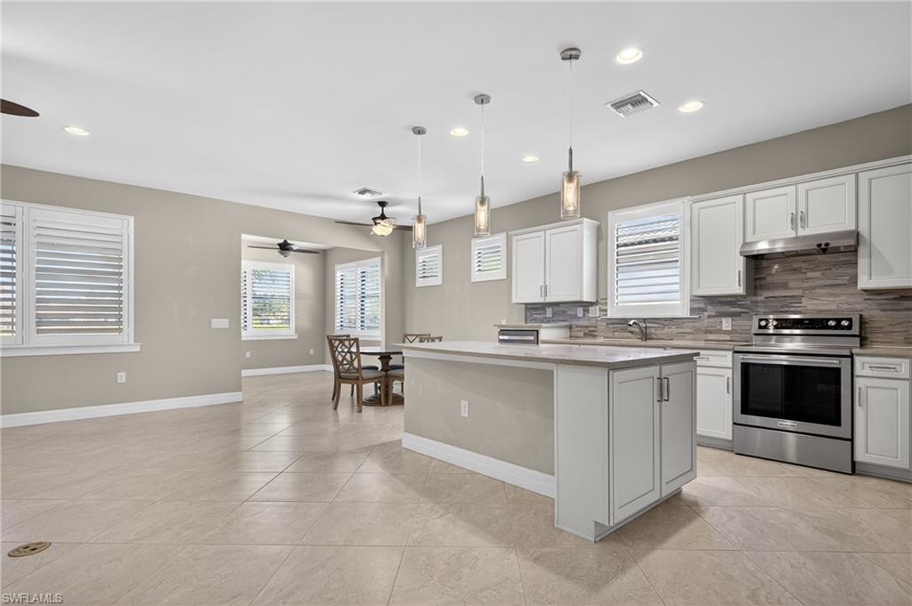 6345 Liberty Street Ave Maria, FL 34142 - Photo 8 of 35 a large white kitchen with stainless steel appliances granite countertop a stove and a sink