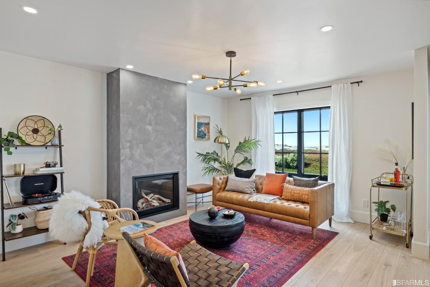 a living room with furniture a chandelier and a fireplace