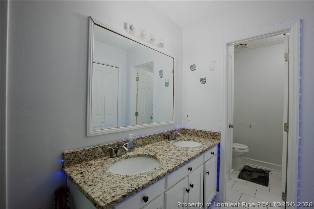 5948 Dalton Road Fayetteville, NC 28314 - Photo 14 of 18 a bathroom with a granite countertop sink and a mirror