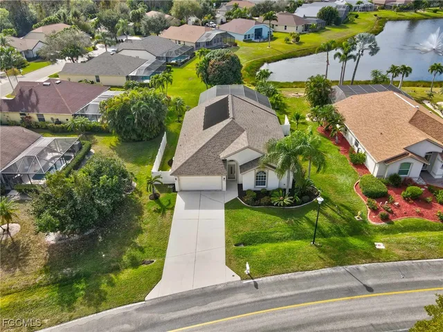 an aerial view of a house with a yard and greenery