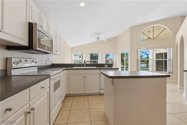 a kitchen with cabinets appliances a sink and a counter top space