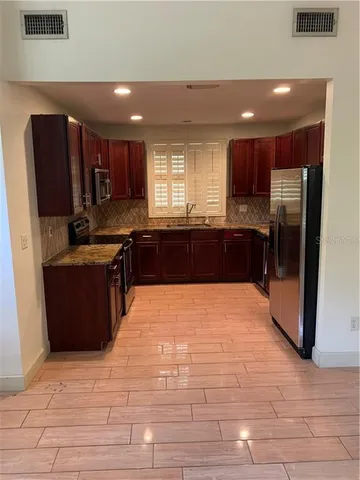 a large kitchen with kitchen island granite countertop a large counter top stainless steel appliances and cabinets