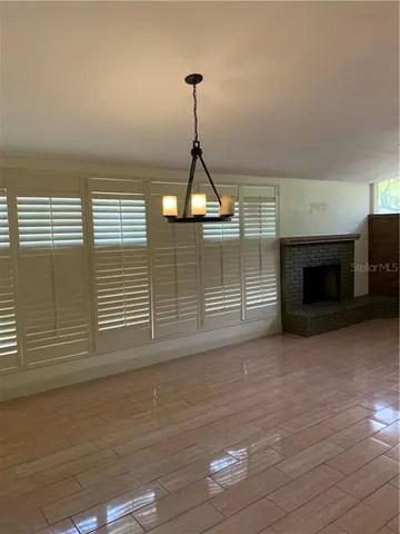a view of empty room with wooden floor and fireplace