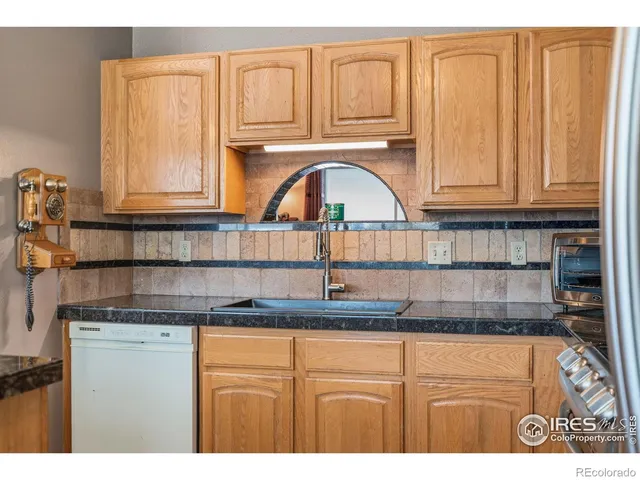a kitchen with granite countertop a sink and cabinets