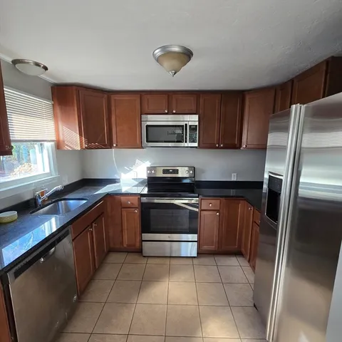 a kitchen with stainless steel appliances granite countertop a refrigerator and a stove top oven