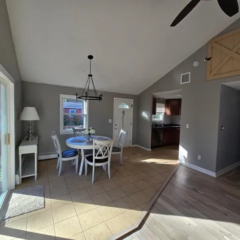 a dining room with furniture a chandelier and wooden floor