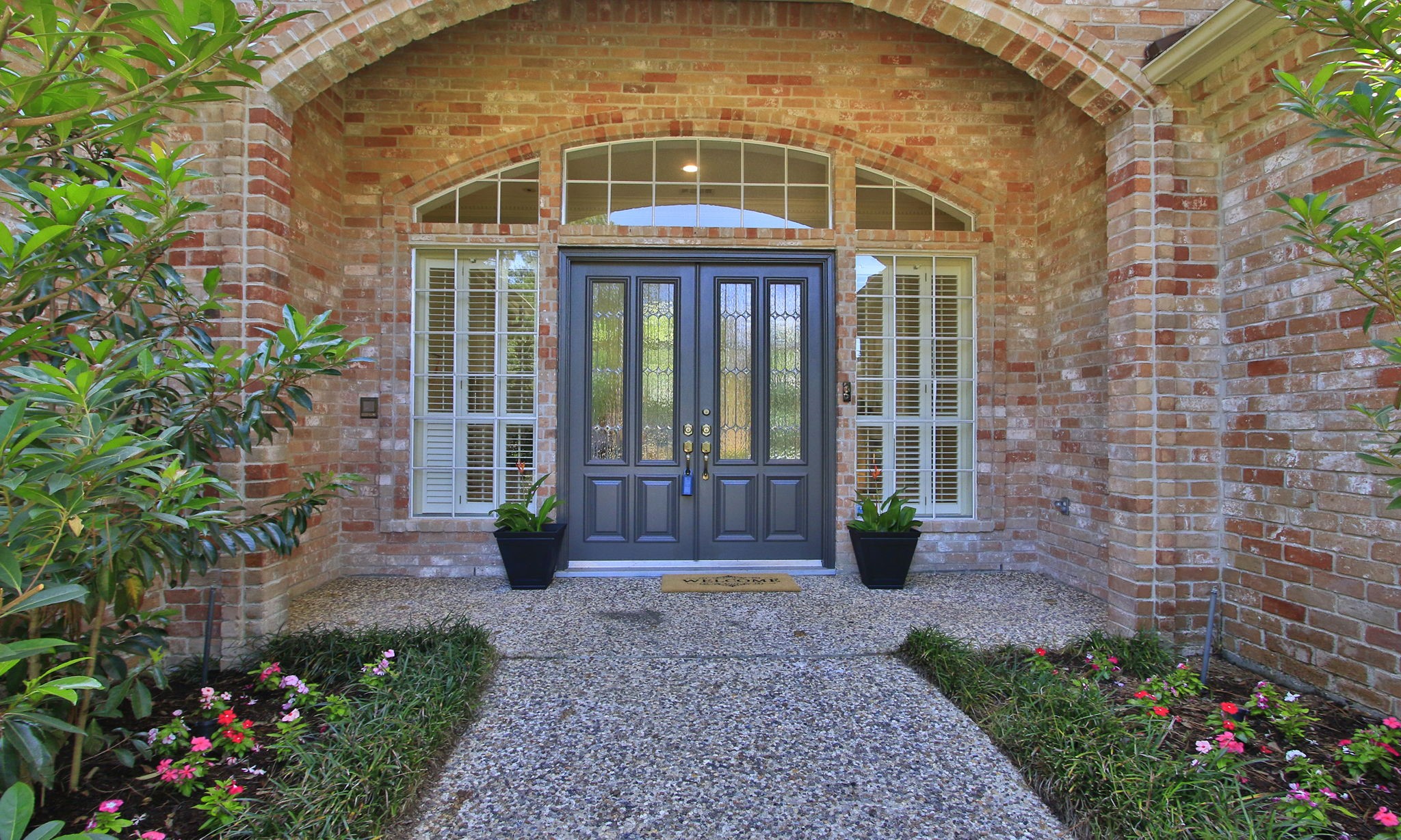 15923 Harwick Drive Spring, TX 77379 - Photo 5 of 50 A brick archway frames the covered entry with side windows framing the recently painted front door.