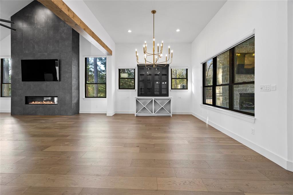 2432 Bellview Circle Tyler, TX 75709 - Photo 17 of 40 an empty room with wooden floor fireplace and windows