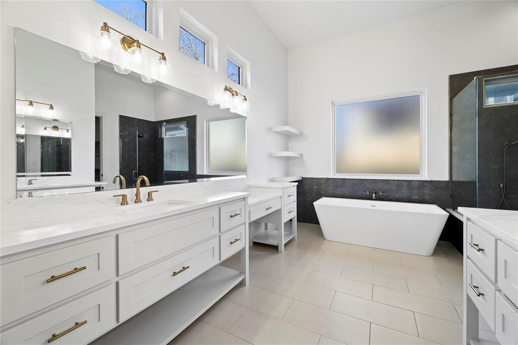 2432 Bellview Circle Tyler, TX 75709 - Photo 21 of 40 a bathroom with a double vanity sink a large mirror and a bathtub