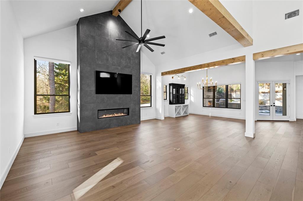 2432 Bellview Circle Tyler, TX 75709 - Photo 22 of 40 an empty room with wooden floor a flat screen tv and windows