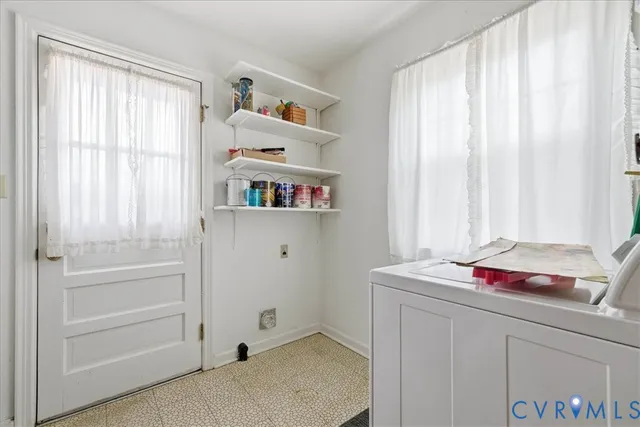 a view of an empty room with chandelier fan and wooden floor