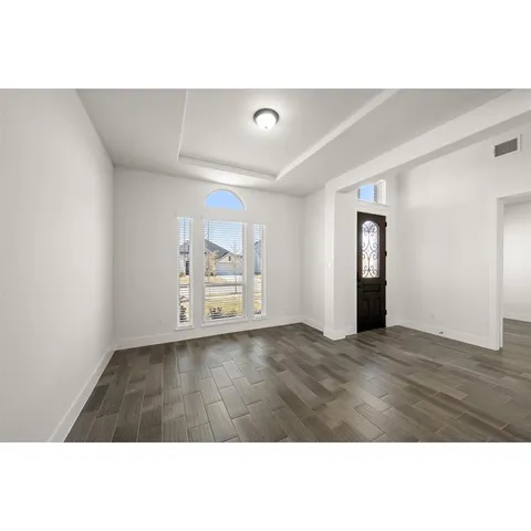 a view of empty room with wooden floor