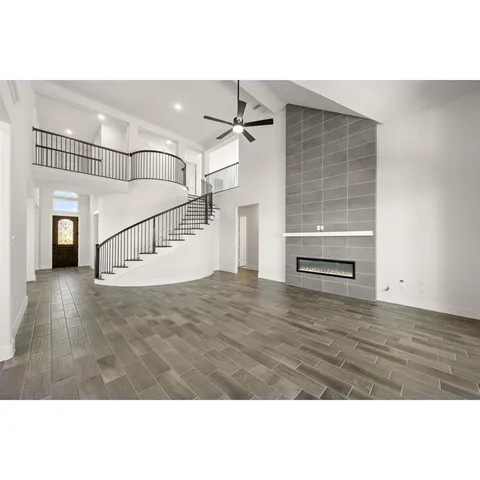 a view of a livingroom with wooden floor and ceiling fan