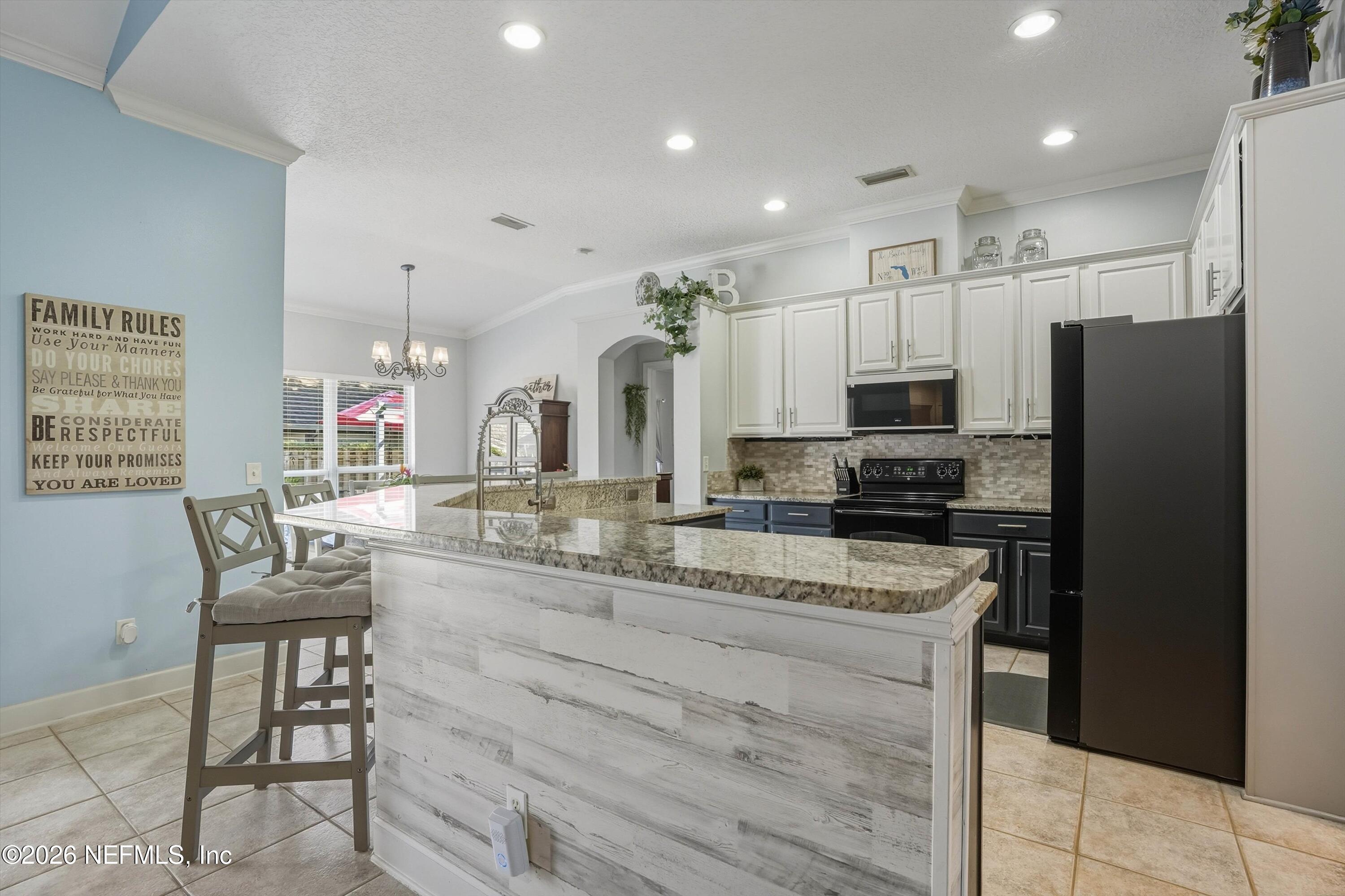 2918 Grande Oaks Way Fleming Island, FL 32003 - Photo 12 of 54 a kitchen with stainless steel appliances granite countertop a refrigerator and a stove top oven