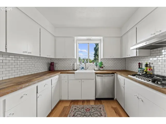 a kitchen with a white cabinets sink and stove