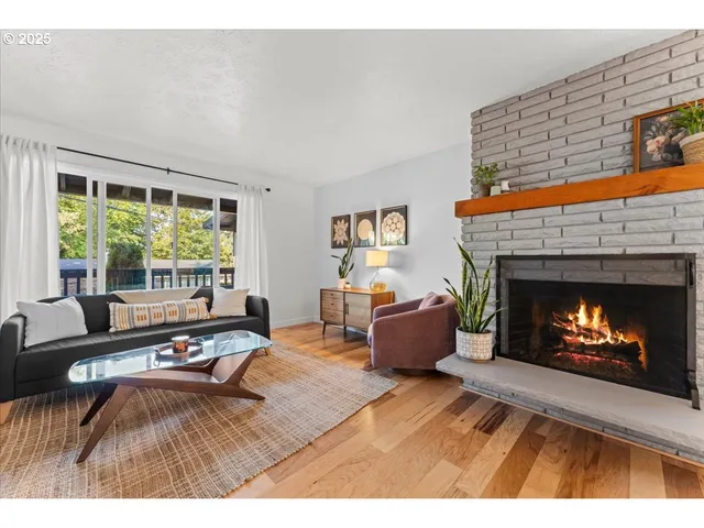 a living room with furniture large window and a fireplace