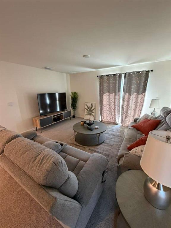 7530 Broad Pointe Drive Zephyrhills, FL 33540 - Photo 2 of 12 a living room with furniture and a flat screen tv
