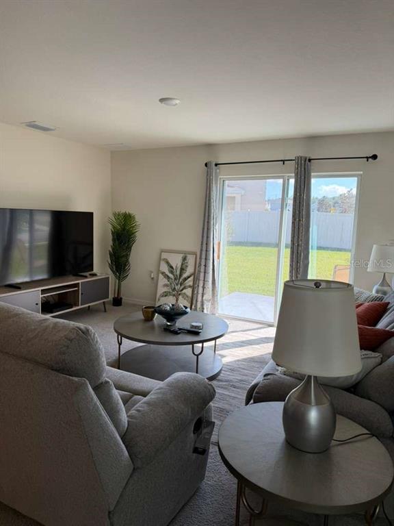 7530 Broad Pointe Drive Zephyrhills, FL 33540 - Photo 4 of 12 a living room with furniture and a flat screen tv