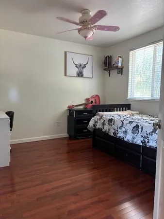a bedroom with a bed and wooden floor
