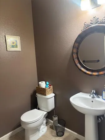 a bathroom with a toilet sink and mirror